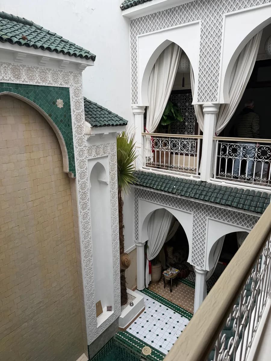 BookNoFees example image: Interior of a riad with patterned tiles and arches