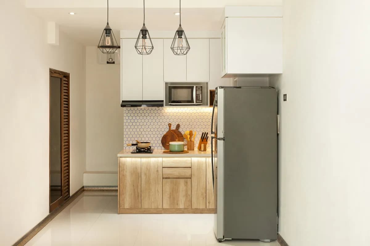 BookNoFees example image: Compact kitchen with wooden fronts, hob and fridge