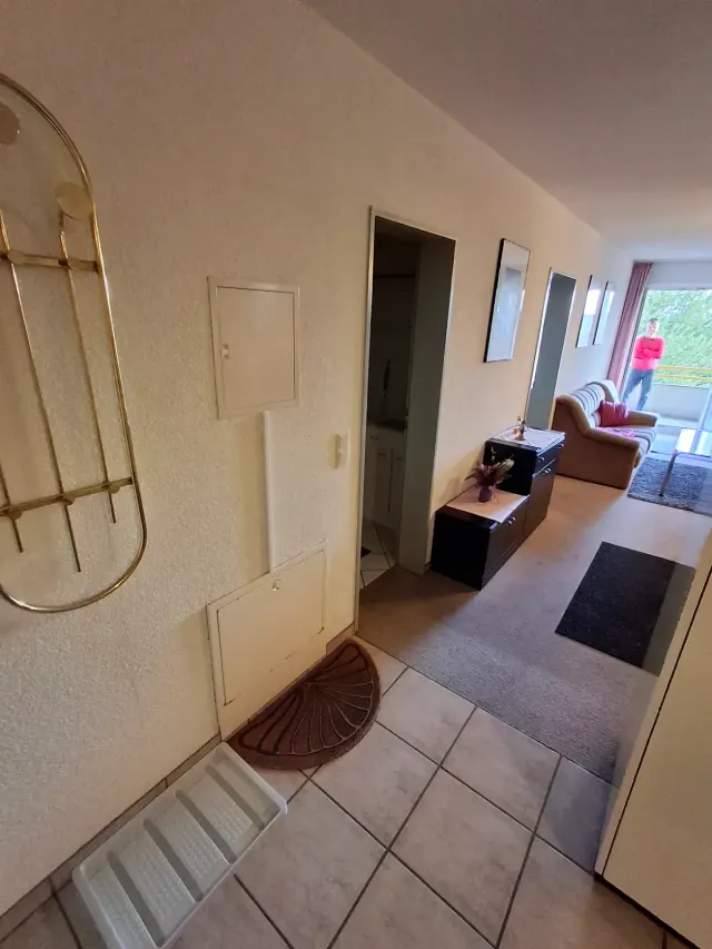 BookNoFees holiday home in Gailingen, Baden-Württemberg, Germany – Hallway with tiled floor, mirror, and view to living room with balcony