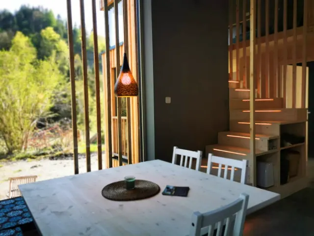 BookNoFees holiday home in Hieflau, Styria, Austria – Dining area with white table, pendant lamp, and wooden staircase with lighting