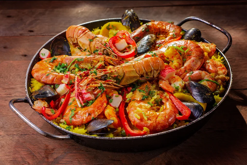 BookNoFees: Example photo: A pan of seafood paella topped with shellfish and red peppers